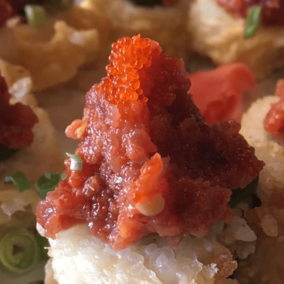 Close-up of Tokyo Dori Sushi and Grill's spicy tuna sushi with bright orange tobiko.