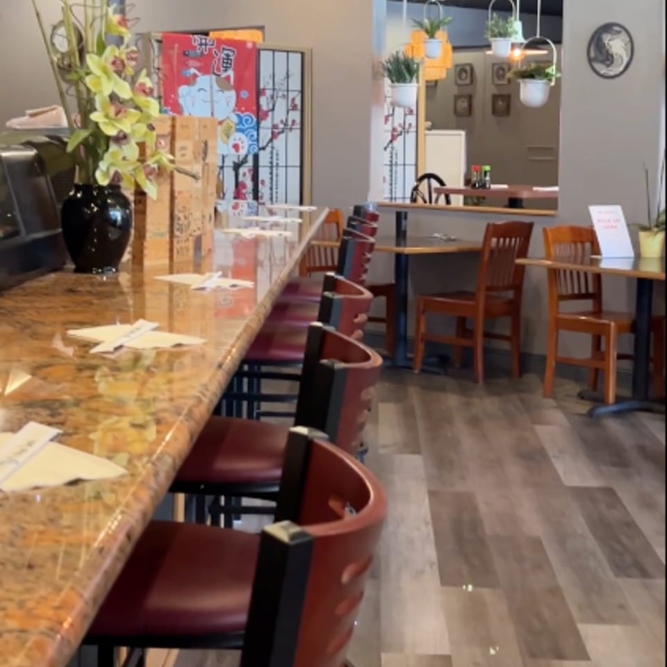 Interior of Tokyo Dori Sushi and Grill with a long sushi bar and dining tables.