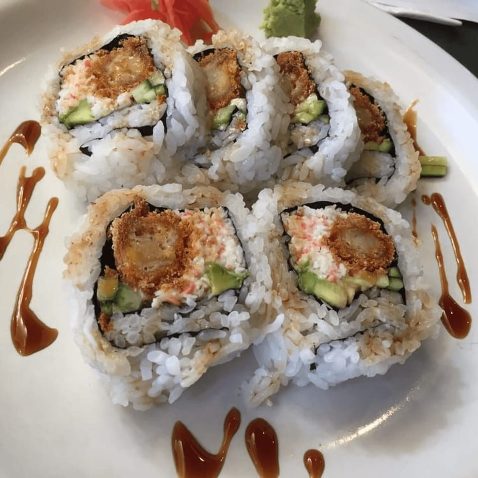 Six Tokyo Dori sushi rolls with tempura shrimp, avocado, and crab, drizzled with sauce.