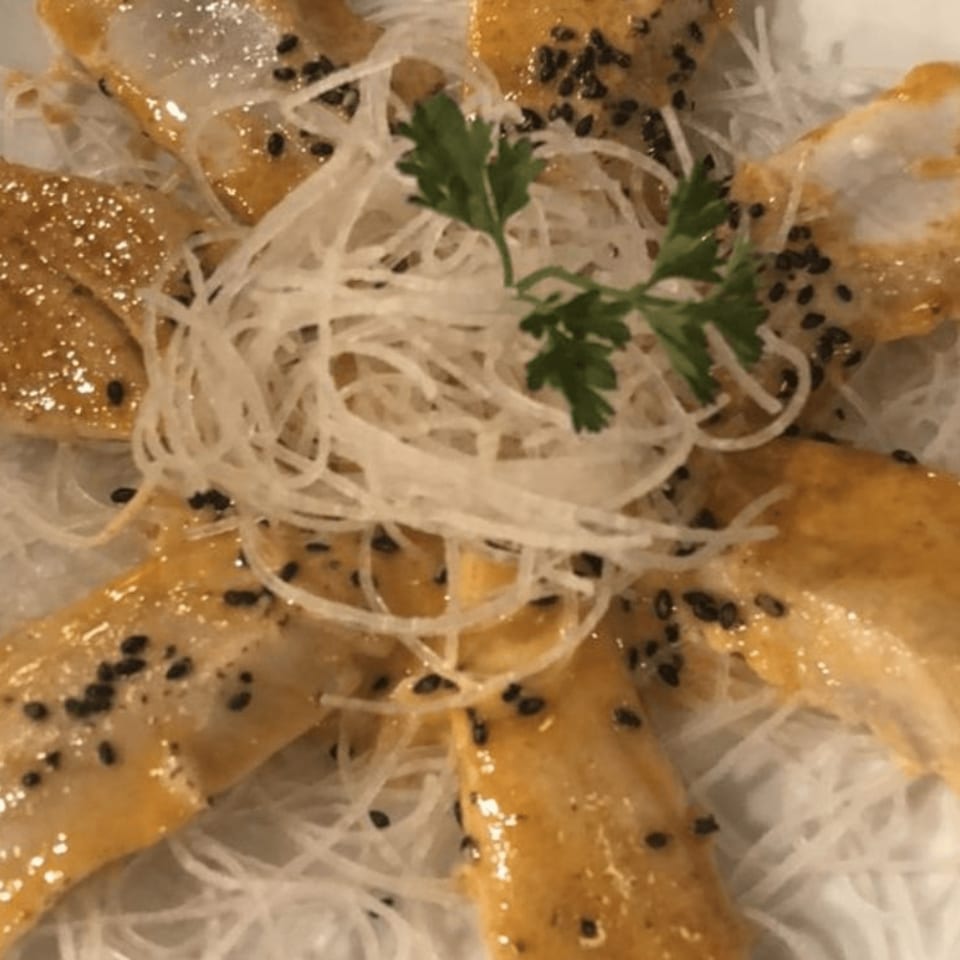 Tokyo Dori's salmon sashimi with sesame seeds, sauce, and shredded daikon radish.